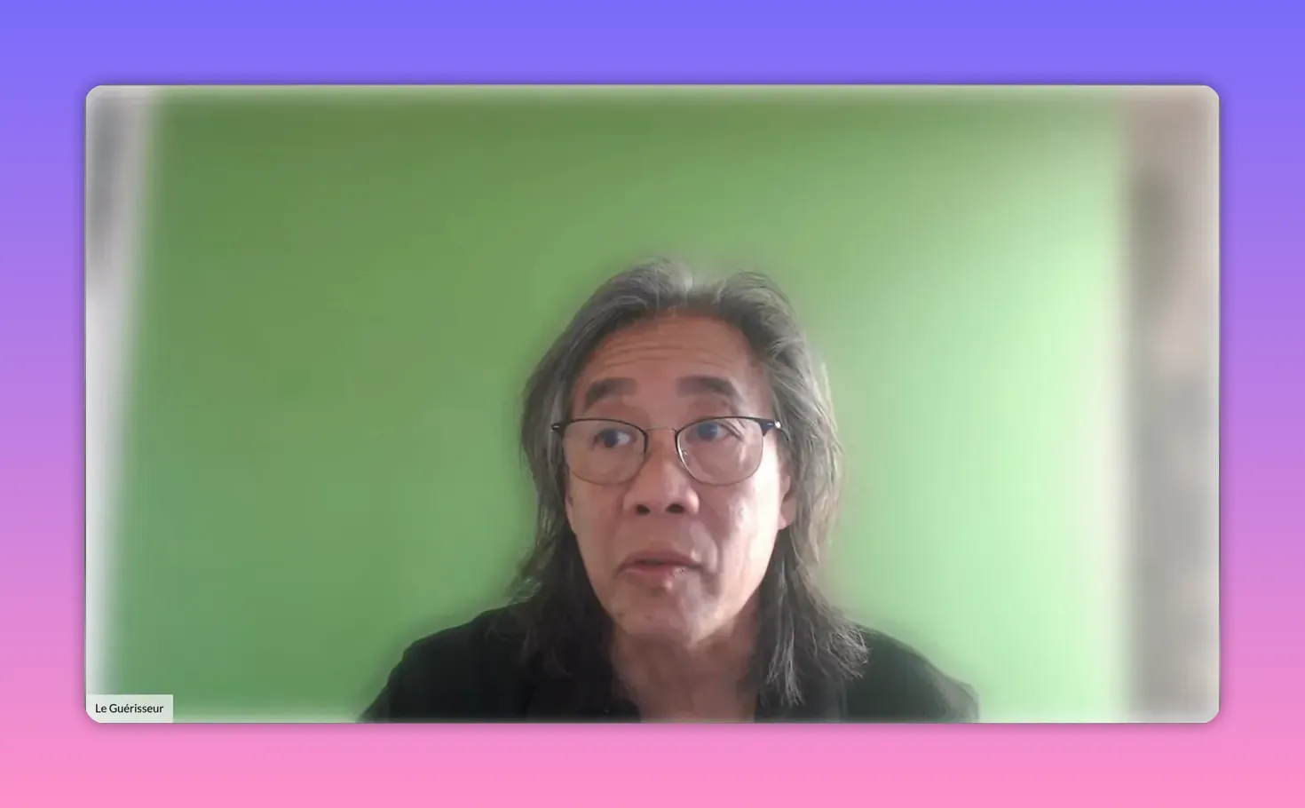 Présentateur cadré de face devant un fond vert, regard tourné légèrement vers le haut droit, expression concentrée