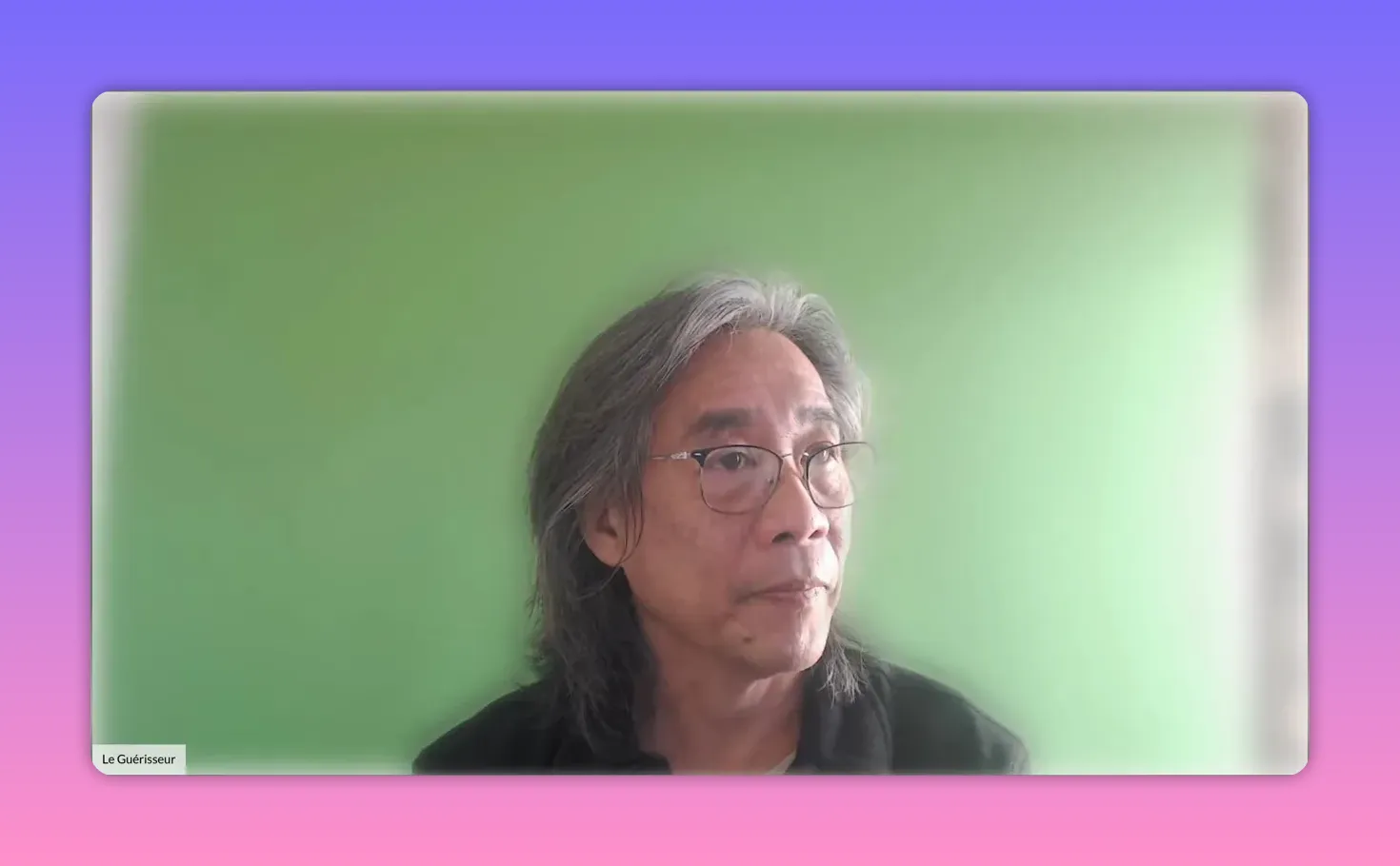 Intervenant regardant vers le haut à droite, posture pensive devant un fond vert.