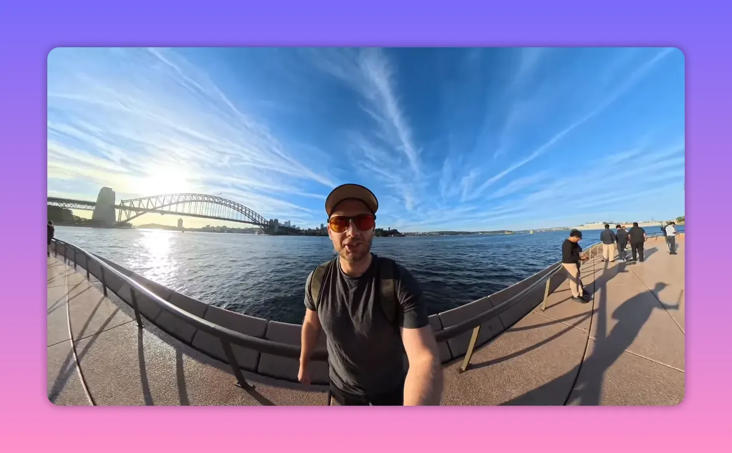 Presenter handheld selfie-style at a harbour with the bridge and skyline behind, demonstrating a run-and-gun recording scenario