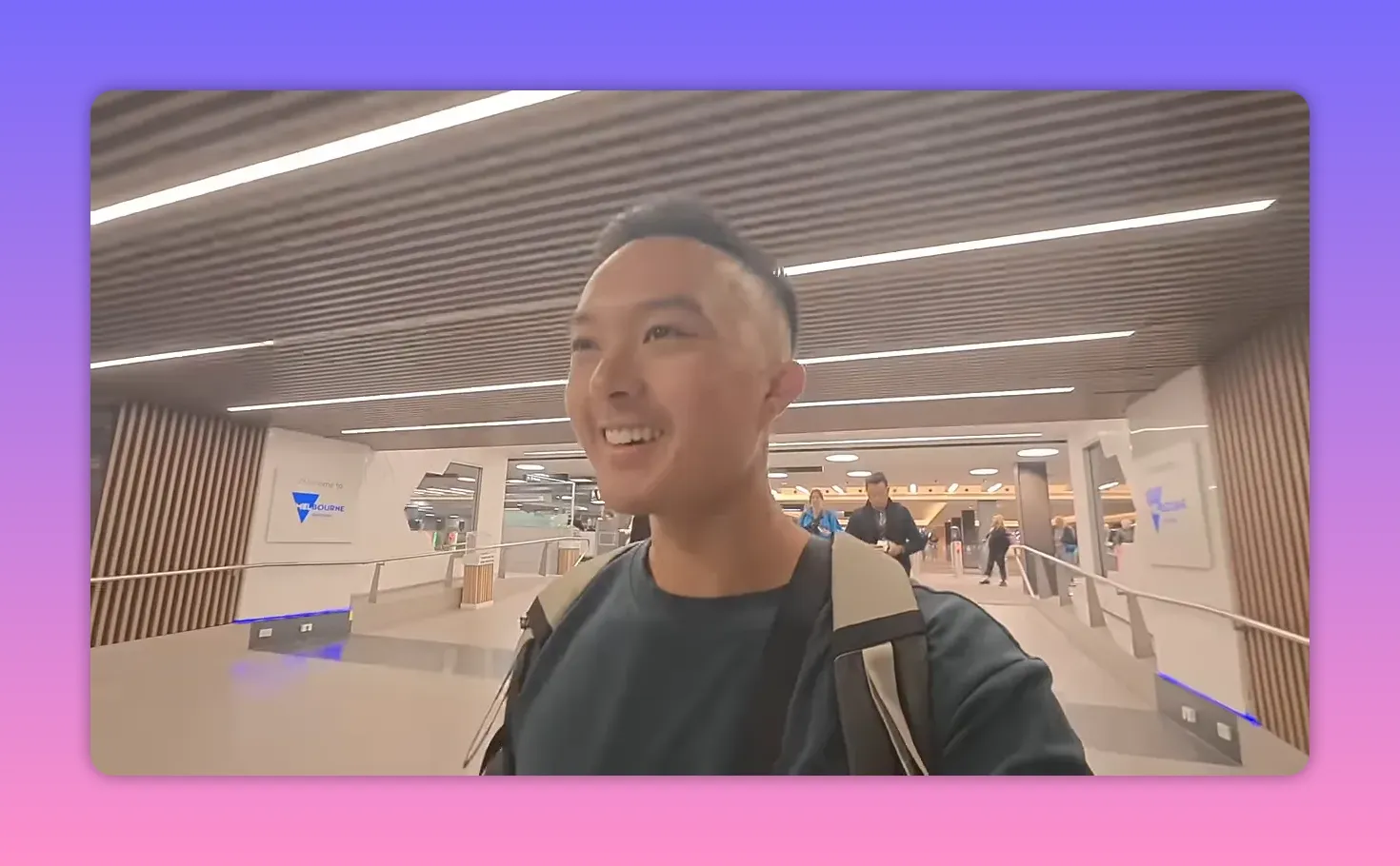 Melbourne airport arrivals hall with a 'Welcome to Melbourne' sign and a smiling traveler.