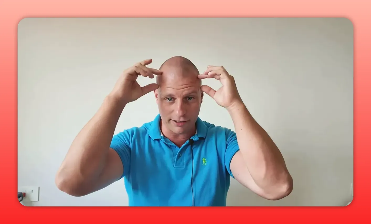 Speaker framing the top of his head with both hands to indicate device placement on the skull