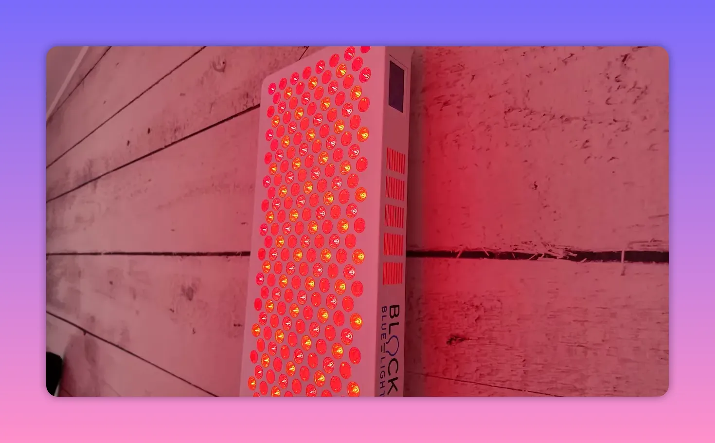 Close-up of a red light therapy LED panel mounted on a wooden wall, showing individual red and near-infrared LEDs
