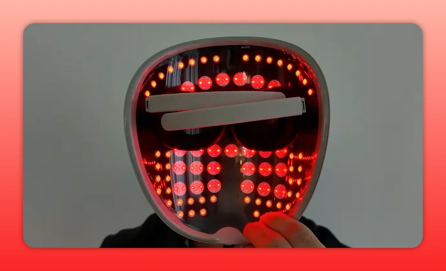 Interior of hard-shell red light therapy mask with many LEDs illuminated and eye supports visible