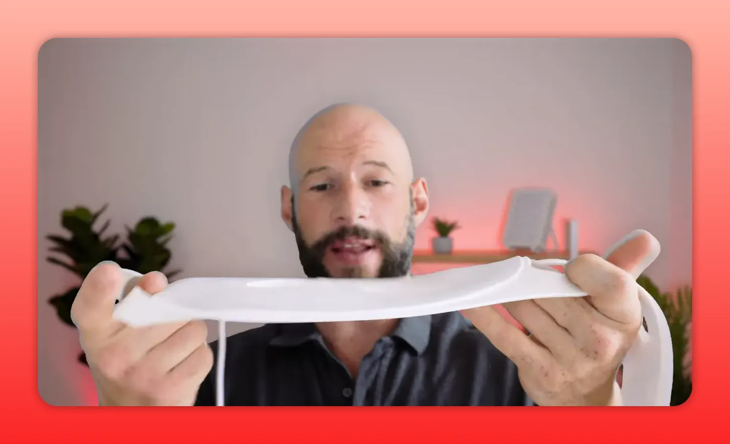 Presenter bends a white soft silicone red-light therapy mask to show flexibility