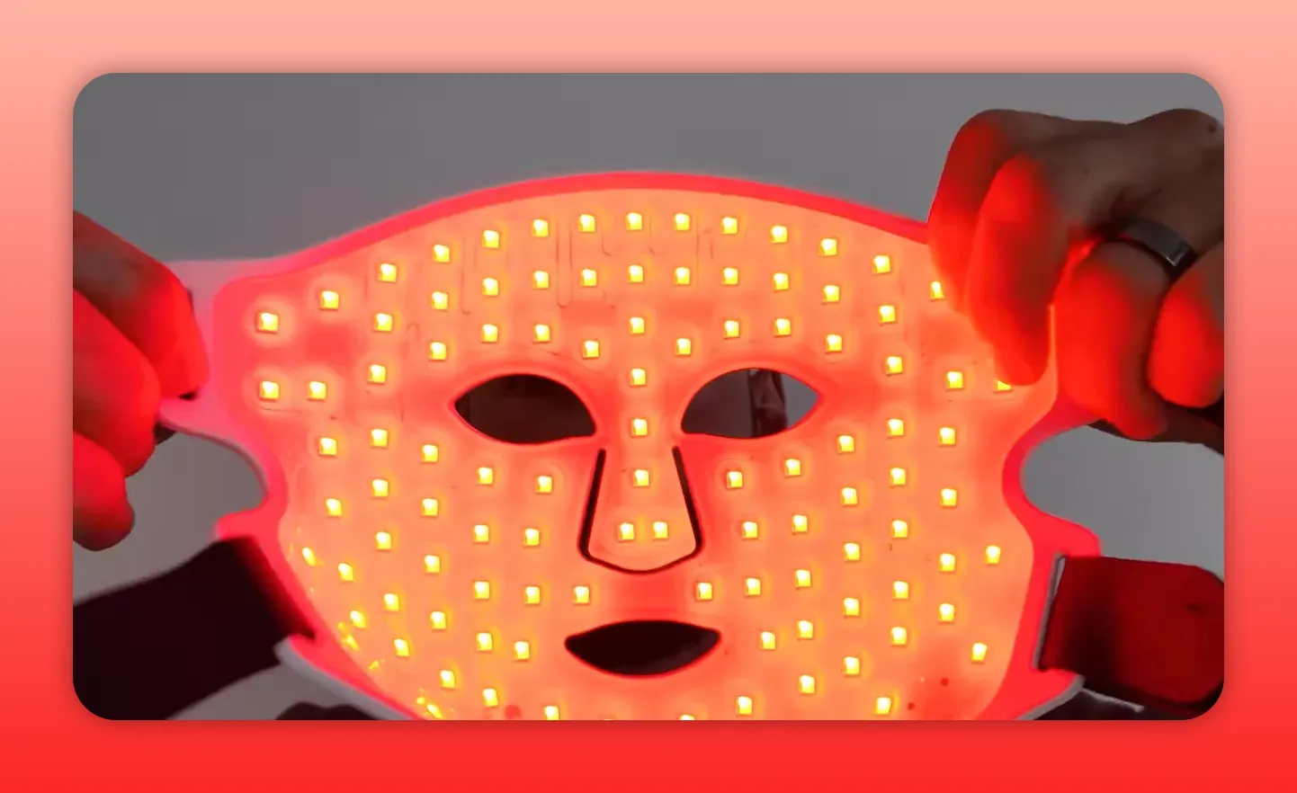 Close-up interior view of CurrentBody Multilight mask showing many illuminated red LED diodes and hand holding mask