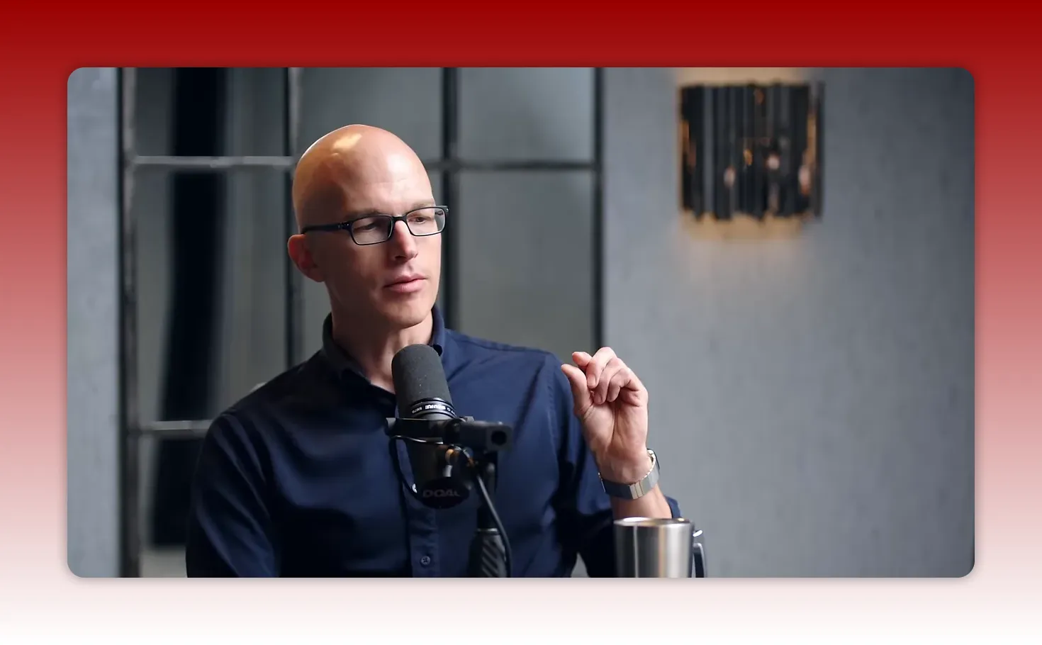 Podcast speaker gesturing with thumb and finger close together while speaking into a microphone