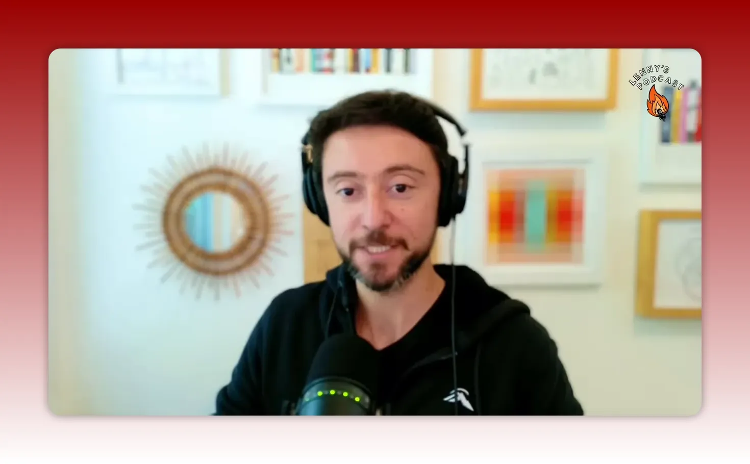 Podcast presenter making a point on camera with headphones and a microphone, clear frontal composition.