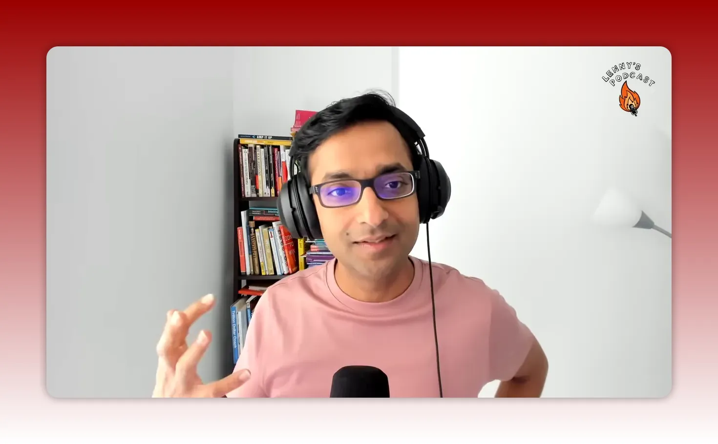 Clear head-and-shoulders shot of host wearing headphones, gesturing while explaining a process