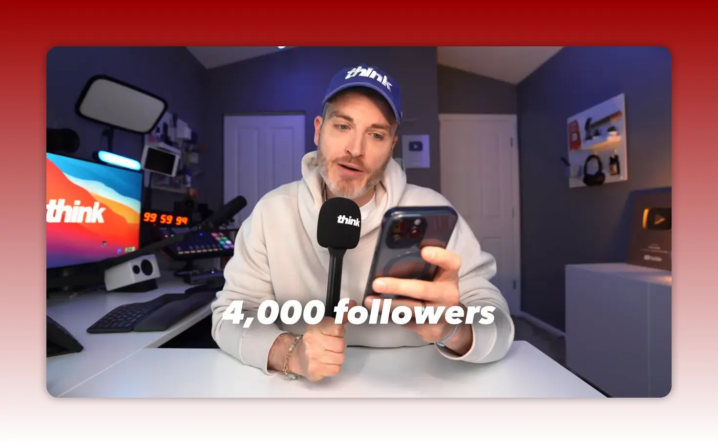 Creator holding a phone with on-screen text '4,000 followers' while speaking into a microphone in a studio.