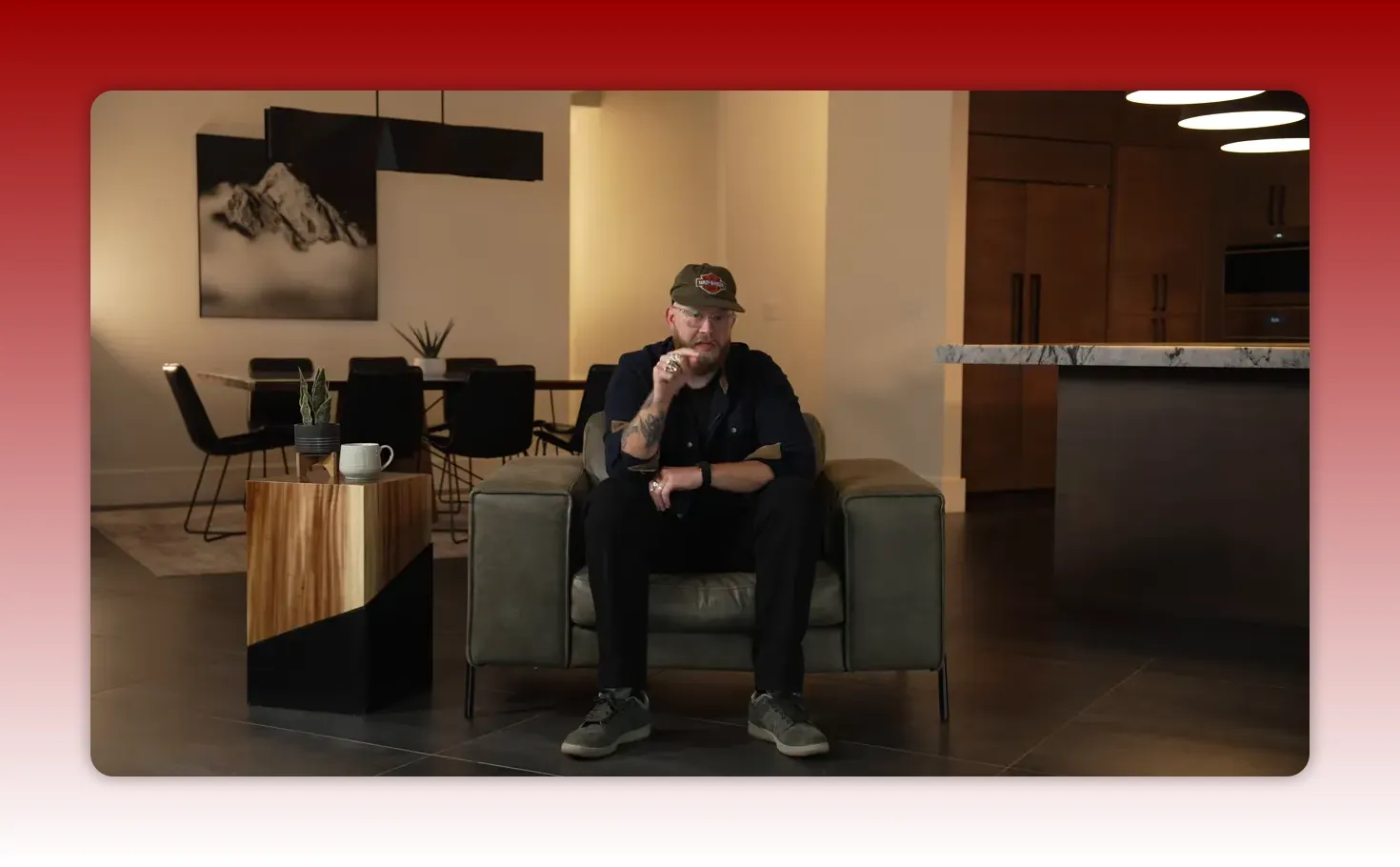 Well-composed shot of presenter seated in a home-studio, pointing to emphasize a key point