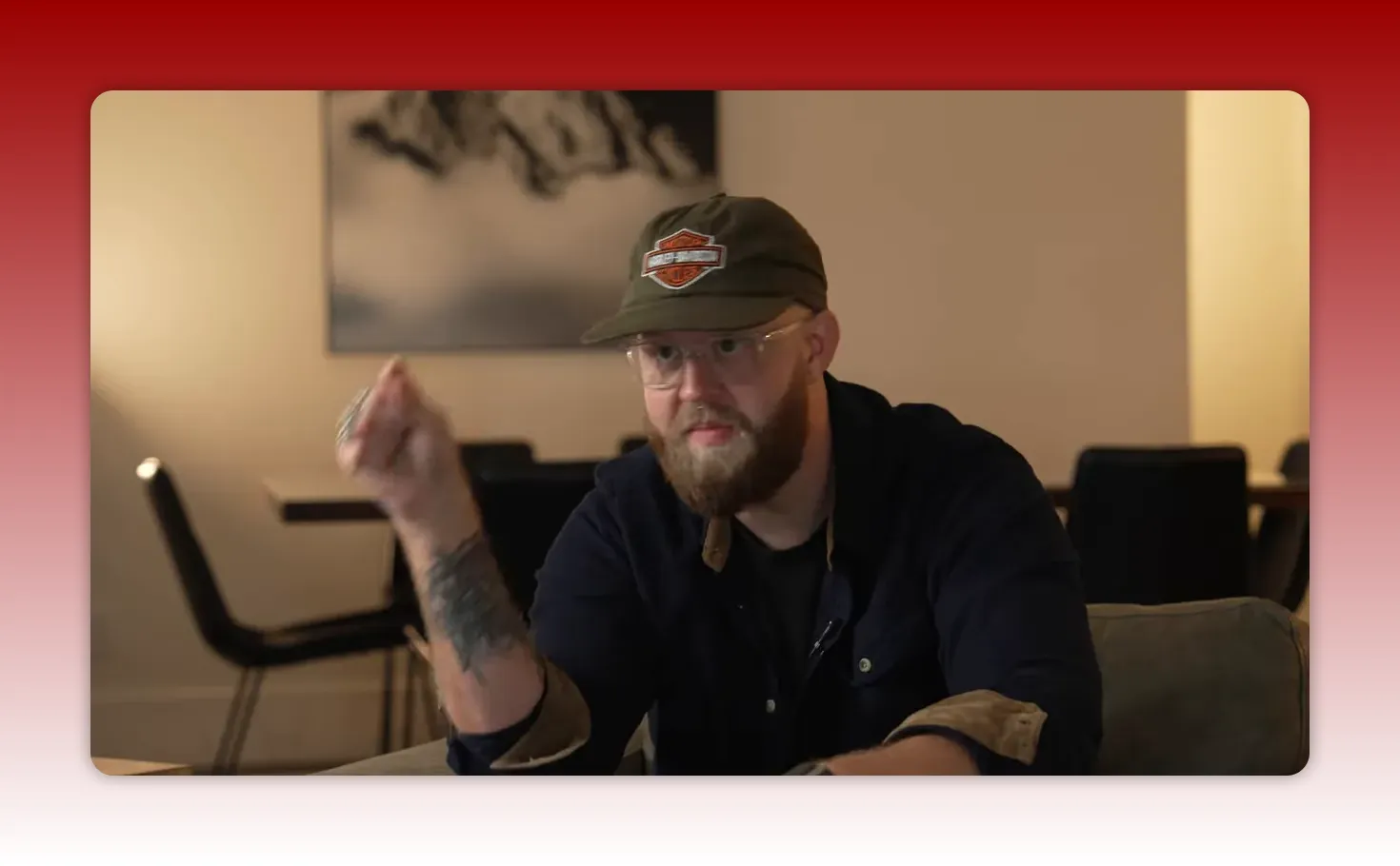 Well-framed medium shot of the presenter gesturing while explaining a point in a living-room style set