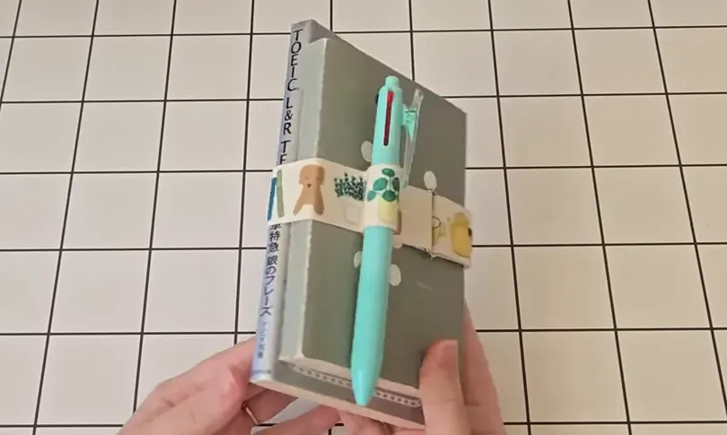 ノートとペン、ペンバンドが並んだ俯瞰の手元写真