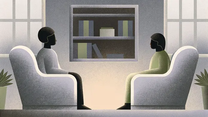 Deux personnes face &agrave; face dans des fauteuils devant une biblioth&egrave;que - s&eacute;ance de coaching psycho-spirituel pour briser les sch&eacute;mas r&eacute;p&eacute;titifs