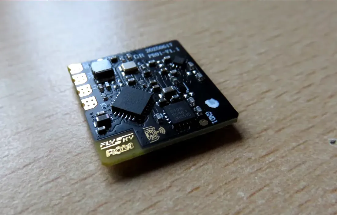 Close-up of FlySky PR01 receiver PCB with FlySky logo visible on the board and antenna connection pads