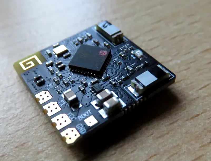 High-detail close-up of the PR01 receiver PCB placed on a wooden table showing SMD components and pads