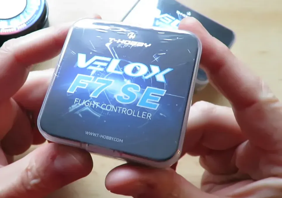 T-Hobby Velox F7 SE flight controller retail box held above a workbench