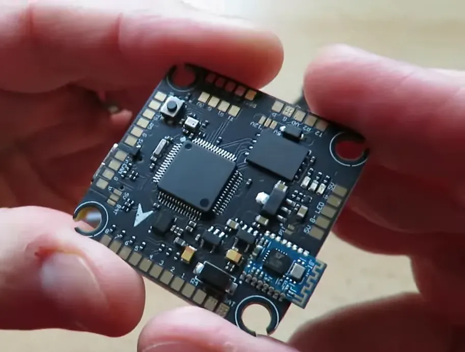 Velox F7 SE flight controller close-up showing the MCU, pads, and Bluetooth module