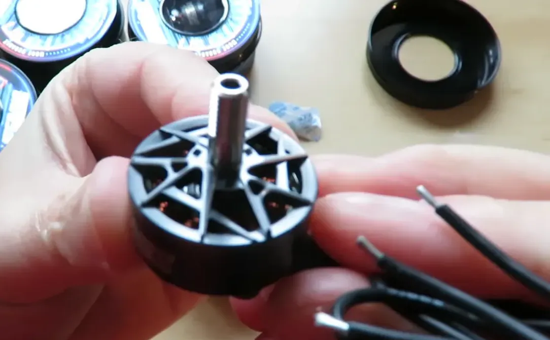 Close-up of an F60-series motor showing the exposed shaft and three motor wires with solder ends