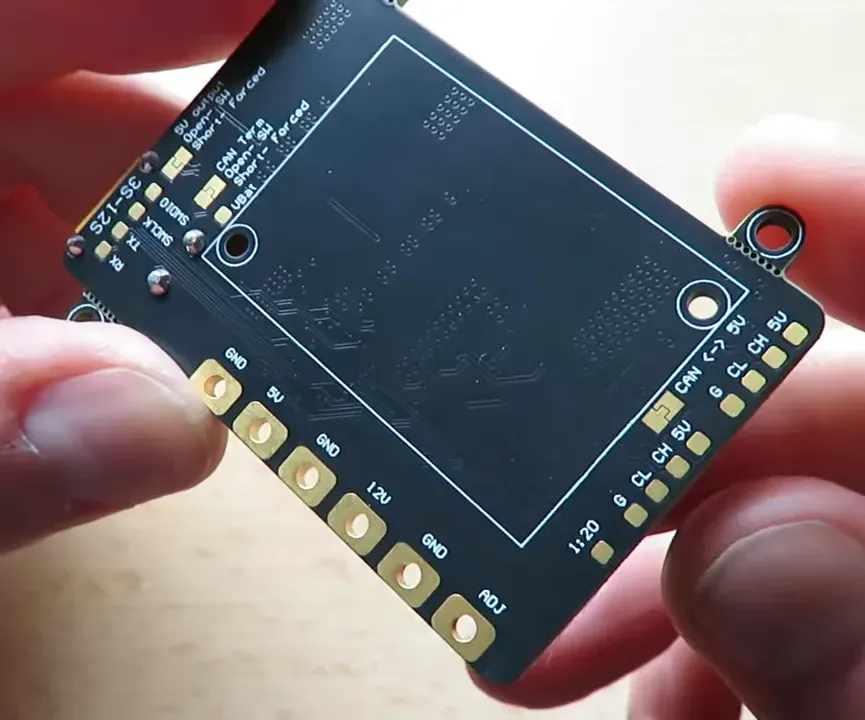 Clear close-up of TBS board back showing GND, 5V, 12V pads and mounting hole suitable for routing a current-carrying lead