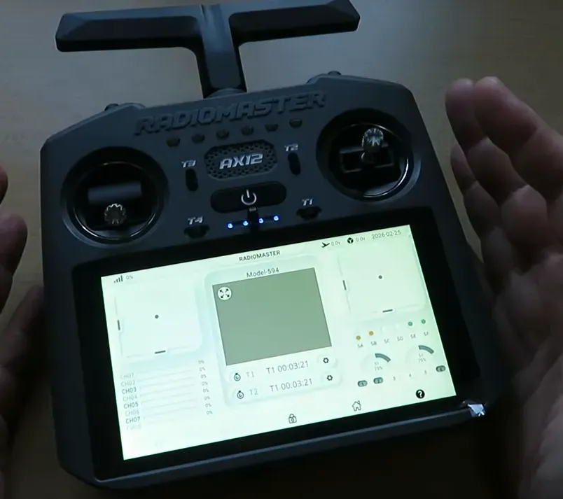 RadioMaster AX12 handheld radio showing the AX app user interface with telemetry and controls on the touchscreen