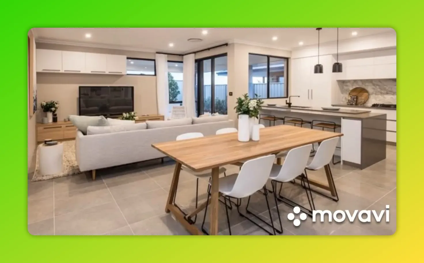 Open-plan kitchen with central island and stools, adjacent dining table and sofa illustrating zoning and flow