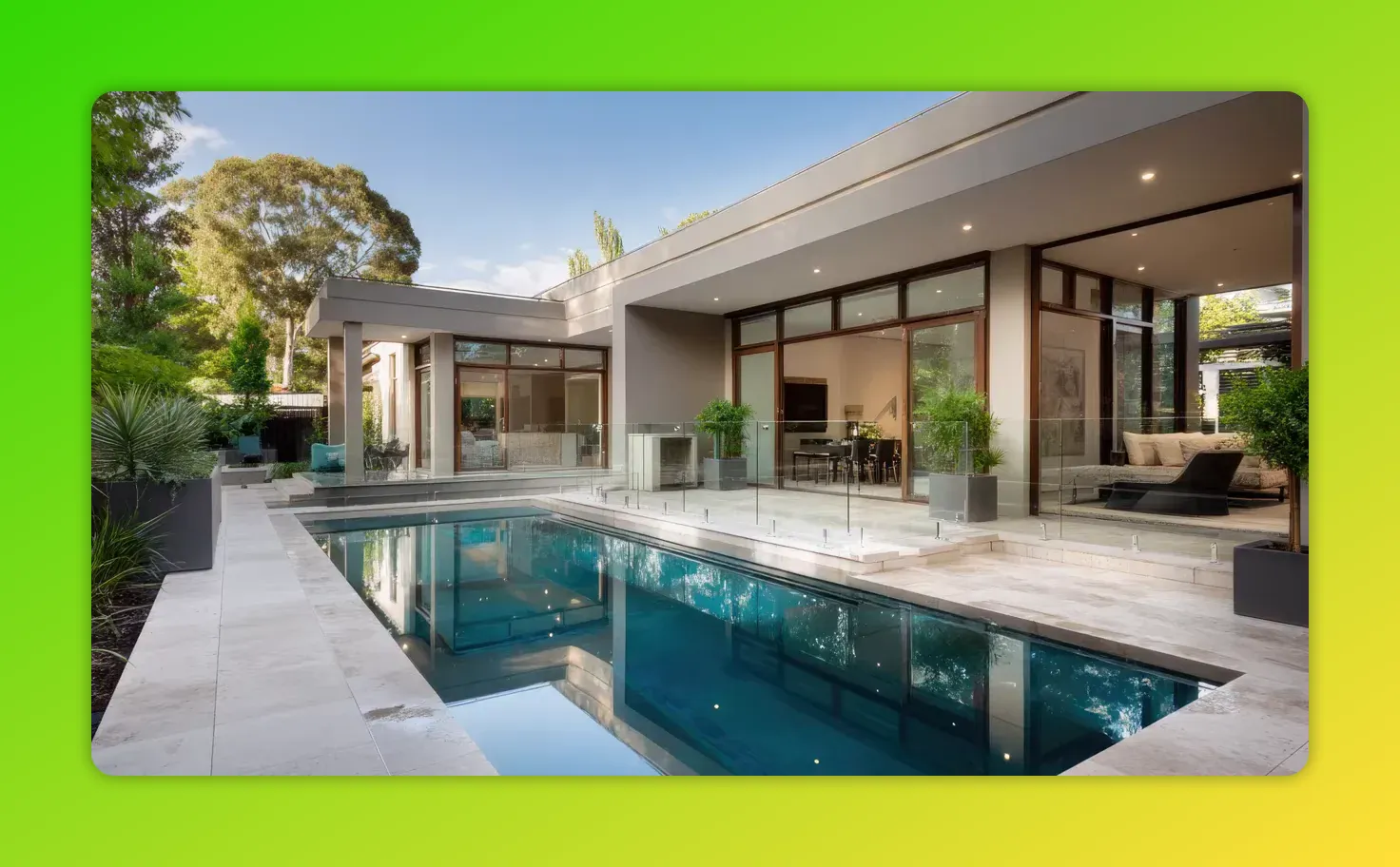Rectangular swimming pool reflecting the house's floor-to-ceiling glazing and clean travertine paving