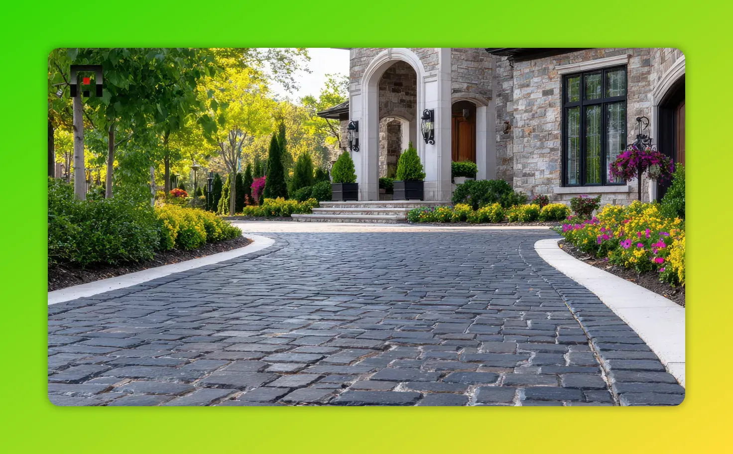 Close-up of dark stone pavers forming a curved path to a house entrance with neat hedges and bright flower borders.