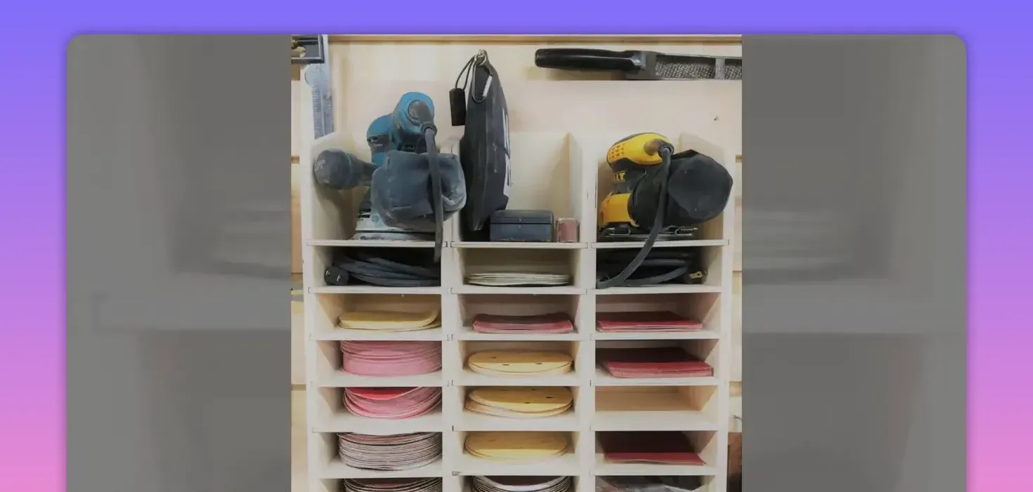 Wooden cubby shelving holding stacks of sanding discs with two sanders on the top row
