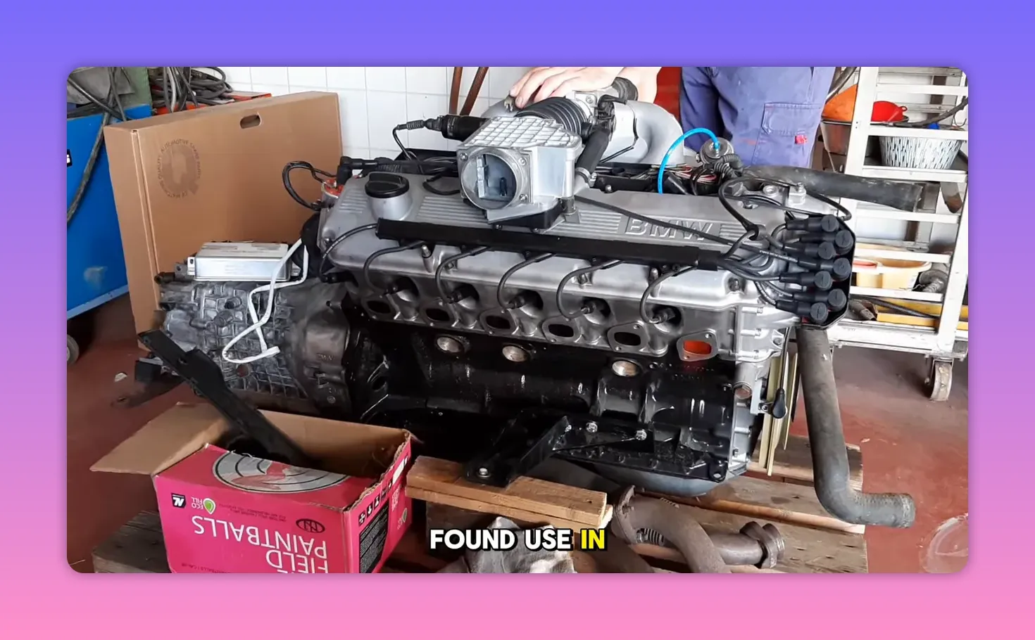 BMW M30 inline-six engine on a stand with intake and ignition visible