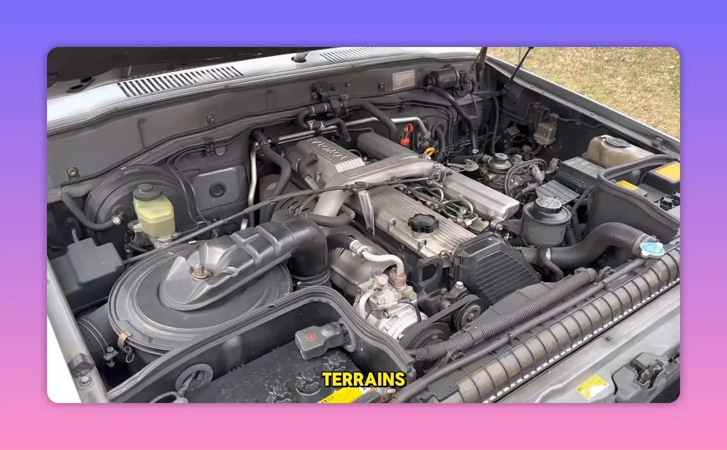 Toyota Land Cruiser inline‑six diesel engine bay showing 'TOYOTA' on the valve cover and simple mechanical components