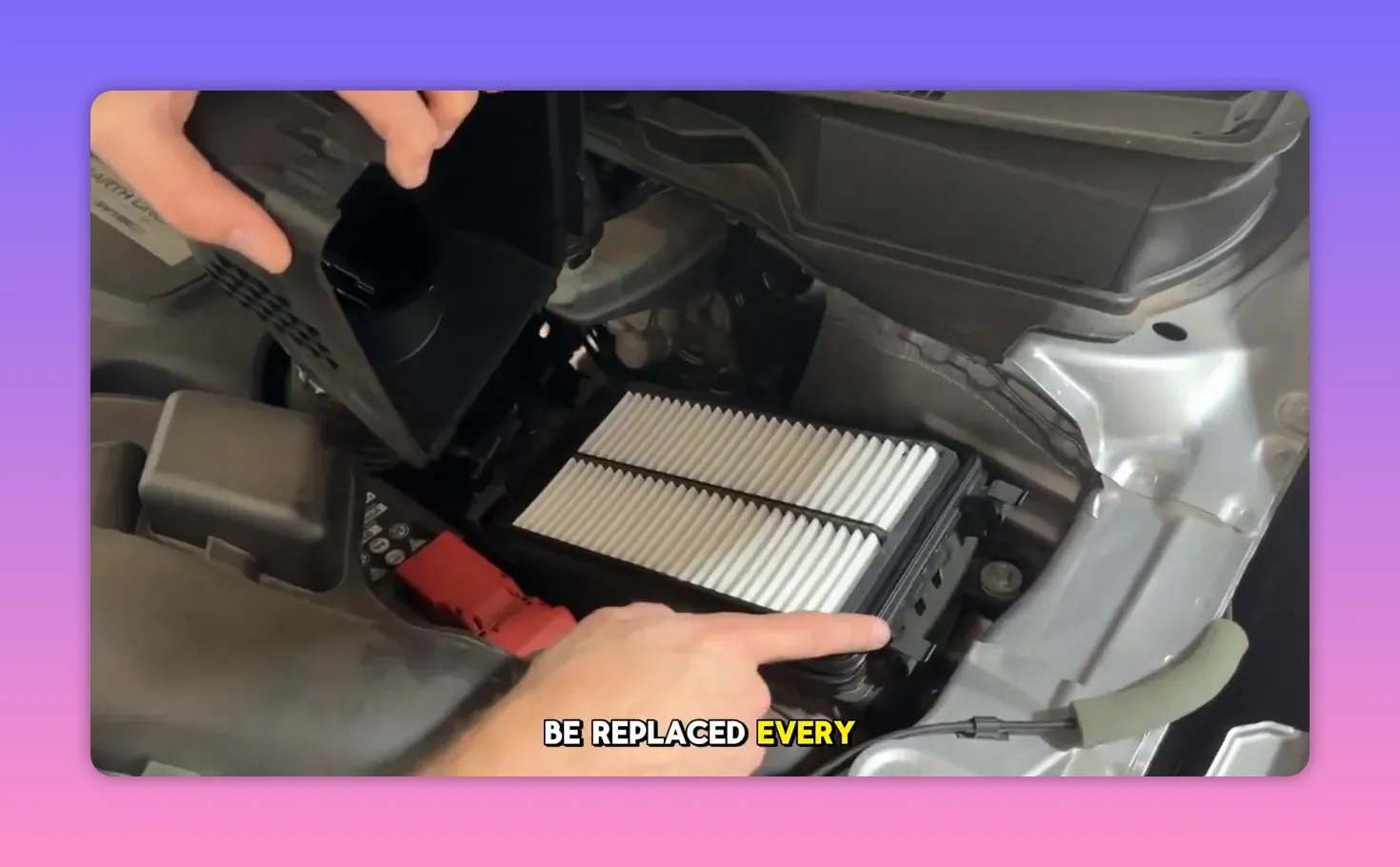 finger pointing at a pleated engine air filter in an open airbox ready to be replaced