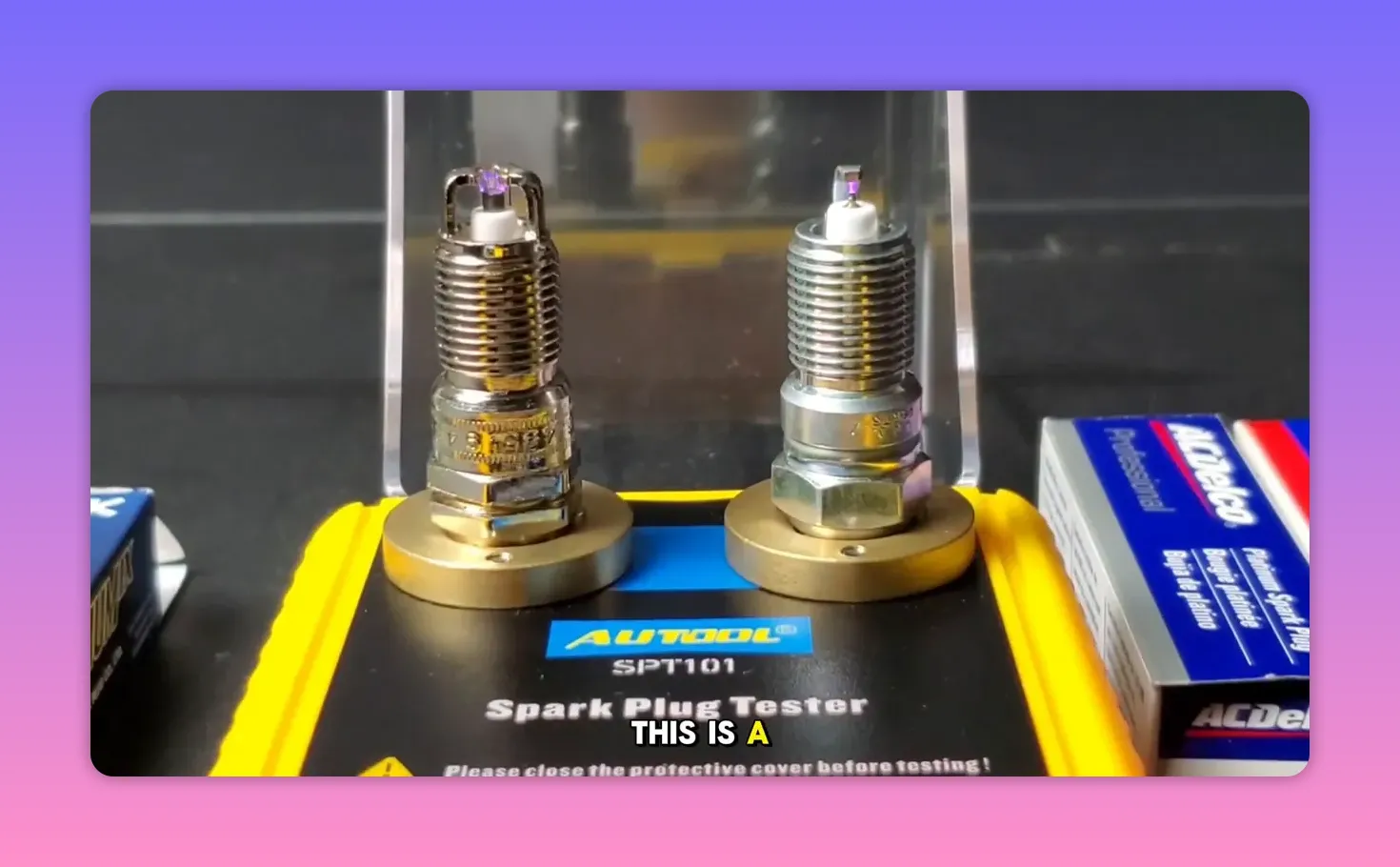 two spark plugs mounted on a spark plug tester with a visible purple spark