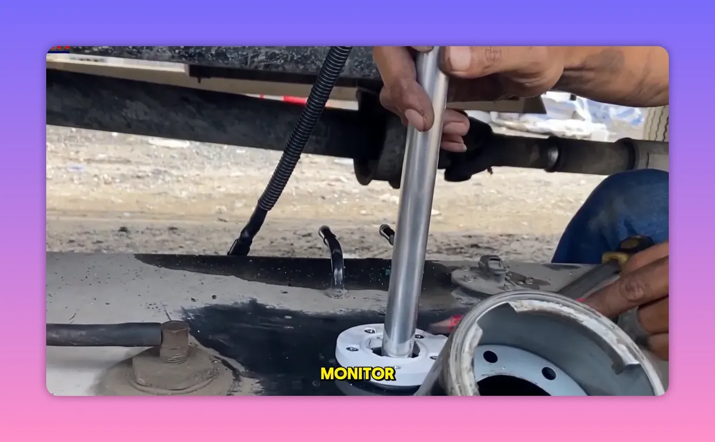 hands inserting a sensor tube into a fuel tank flange during installation beneath a vehicle