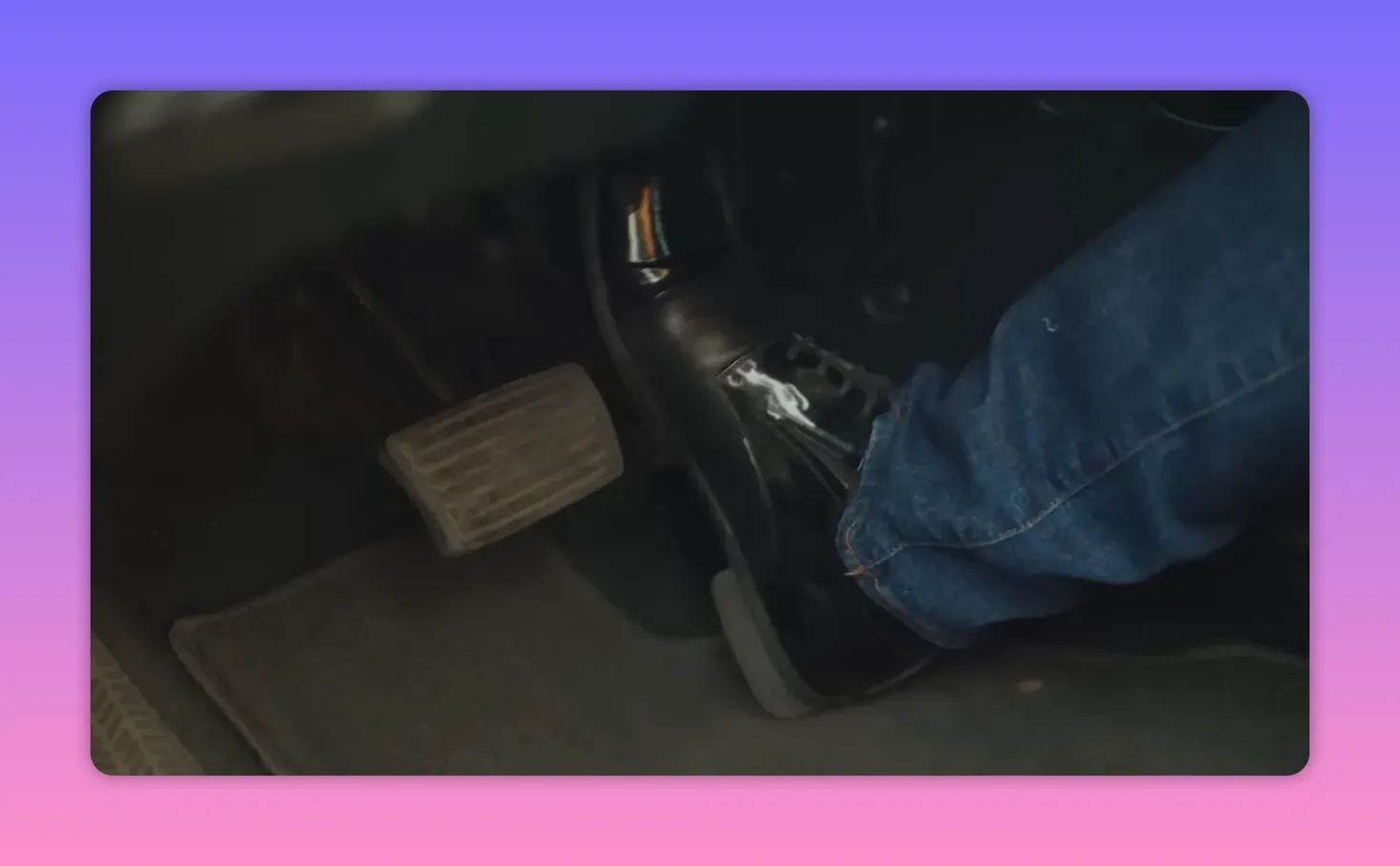 Close-up of a driver's foot pressing the accelerator pedal in a car footwell.