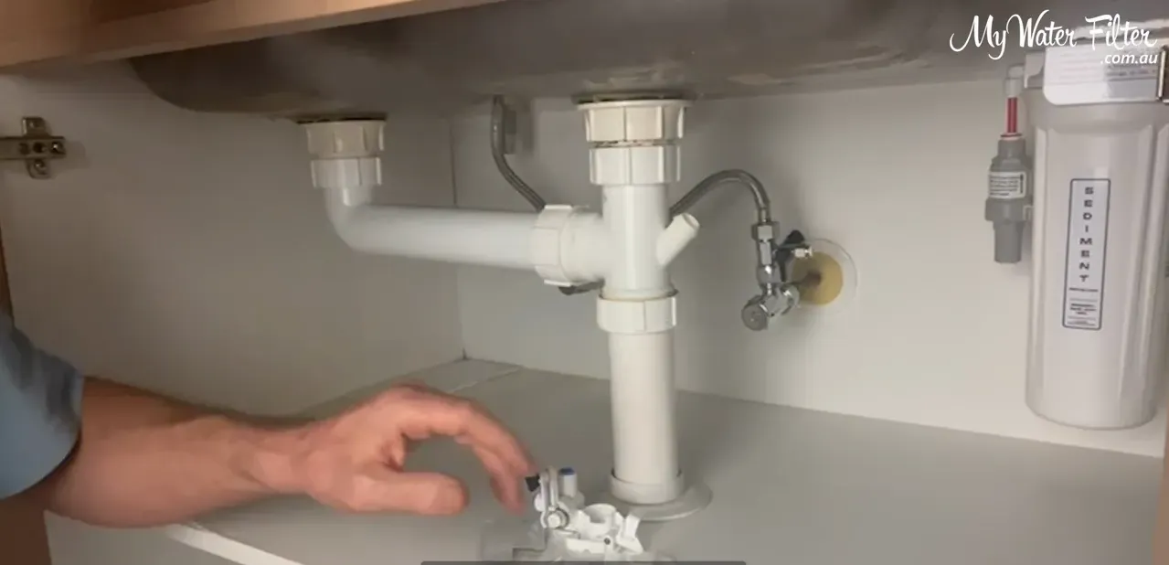 Testing cupboard low spot by dropping water and observing flow