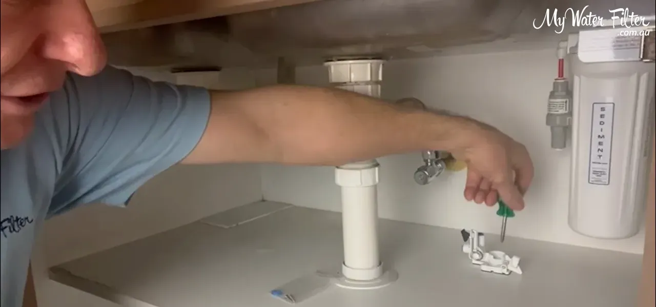 Screwing the detector into the cupboard floor for secure mounting