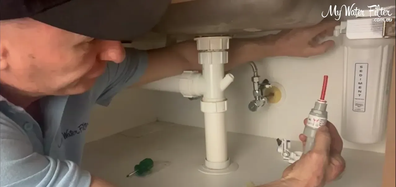 Pushing in the collar to release the hose from the quick‑connect fitting