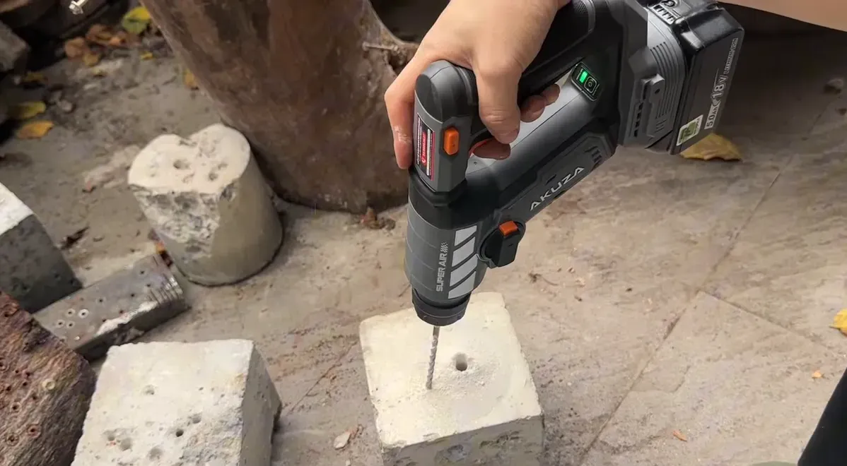 Máy khoan Akuza khoan mũi 6mm trên khối bê tông, logo rõ