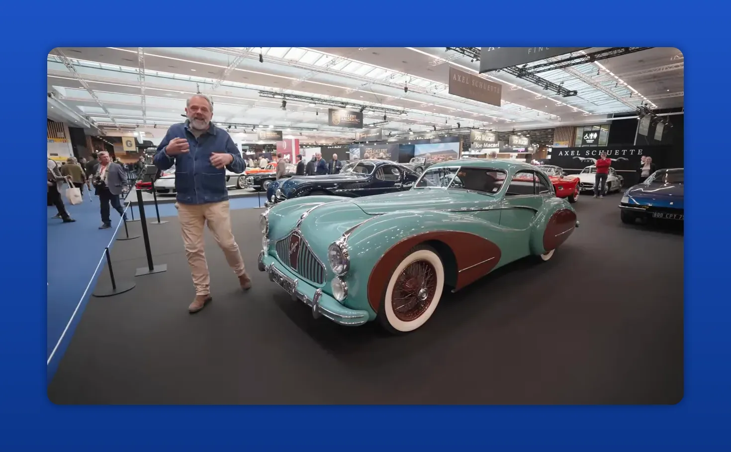 Volledig aanzicht van een turquoise en bruine pre‑1950 sportwagen in een beursstand, scherp en goed belicht.