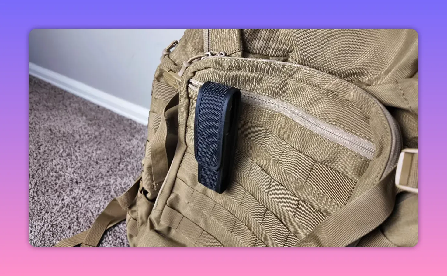 Black flashlight holster attached to the MOLLE webbing on a tan tactical backpack