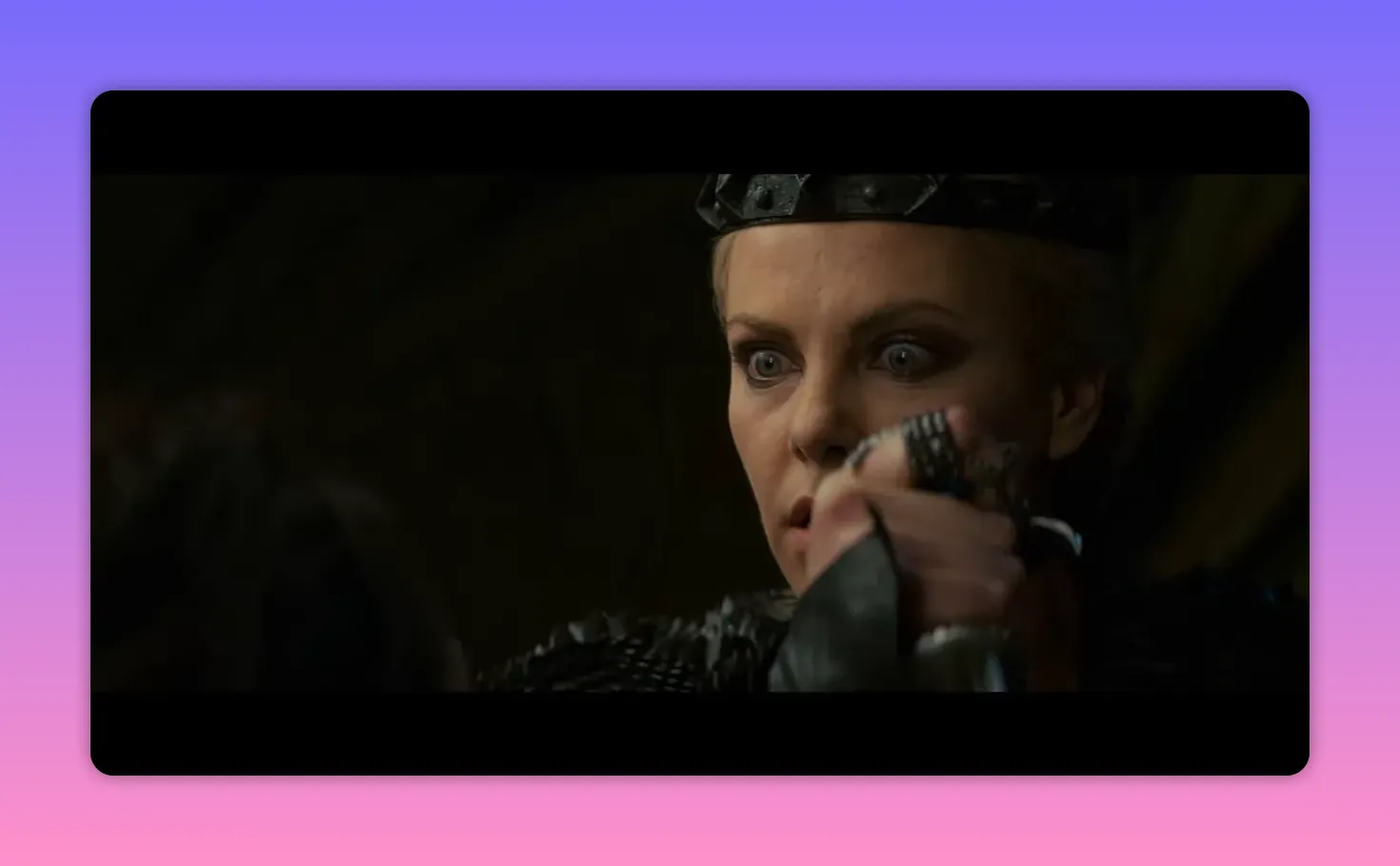 The queen's wide-eyed face with a hand holding a dagger close to her, showing tension