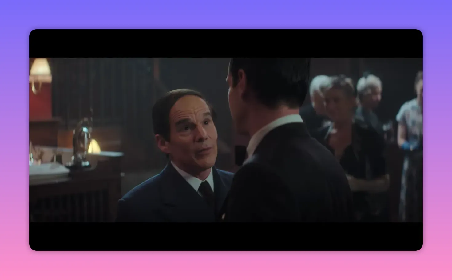 close-up of two men talking at a reception, one looking up with an earnest expression while the other listens