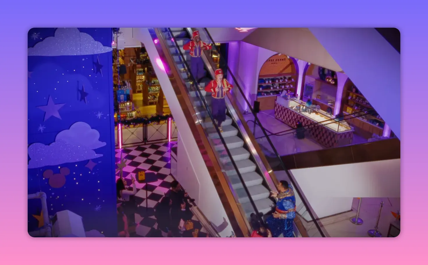 Wide shot of two performers coming down an escalator as a lead singer performs on the ground floor and shoppers watch at Selfridges.