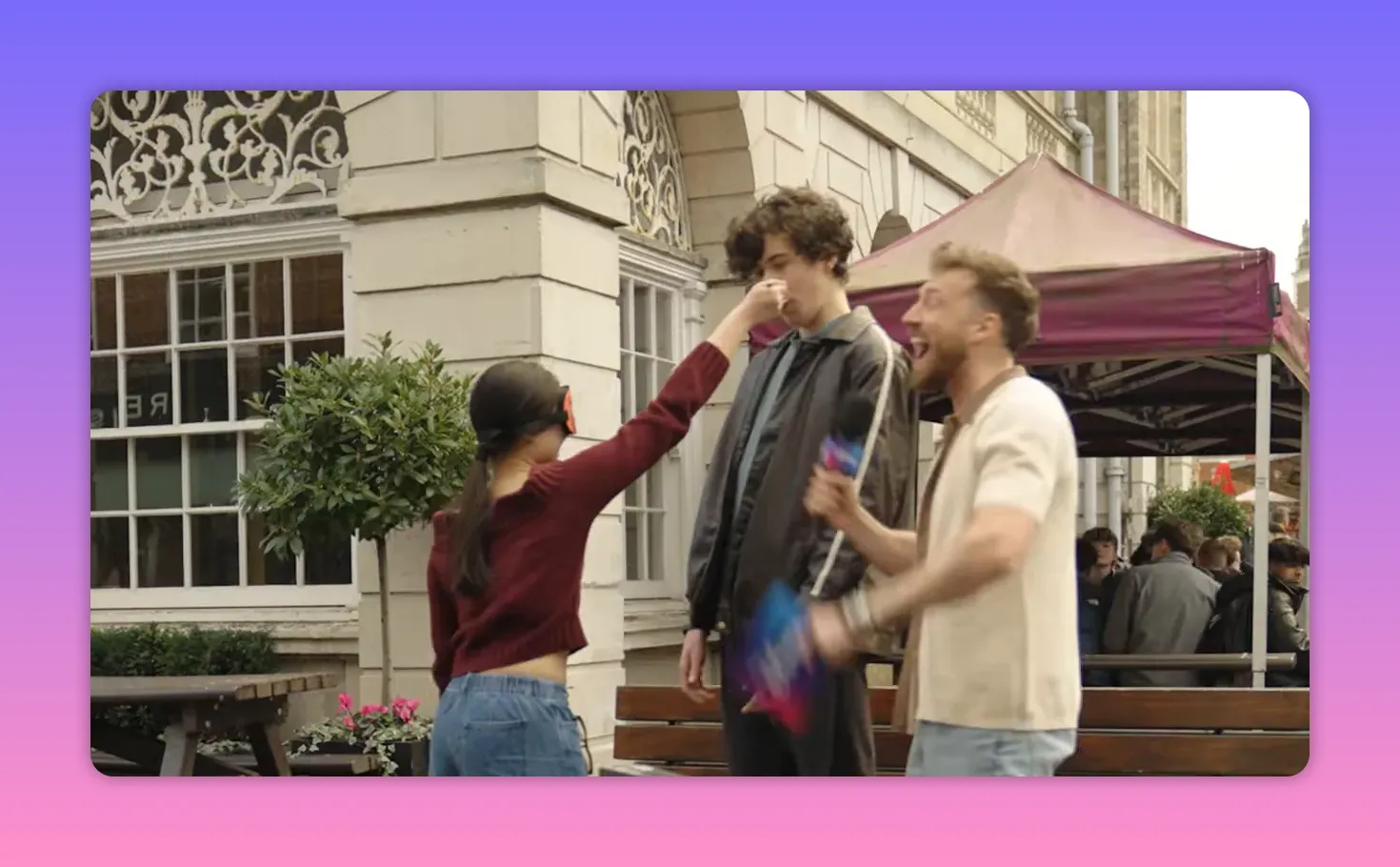 blindfolded contestant reaching out and touching a tall participant while the host laughs animatedly during a street microgame