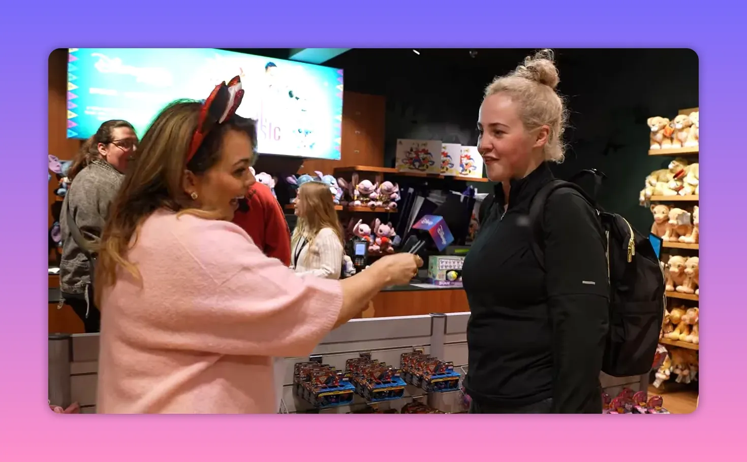 Presenter extending a microphone to a customer at the checkout in a Disney Store