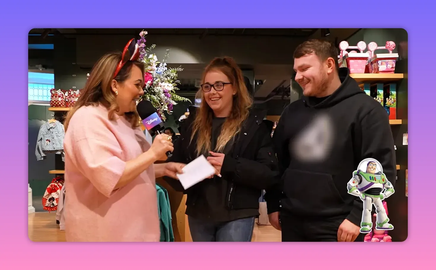 Host with Disney microphone and two shoppers smiling during an in-store game