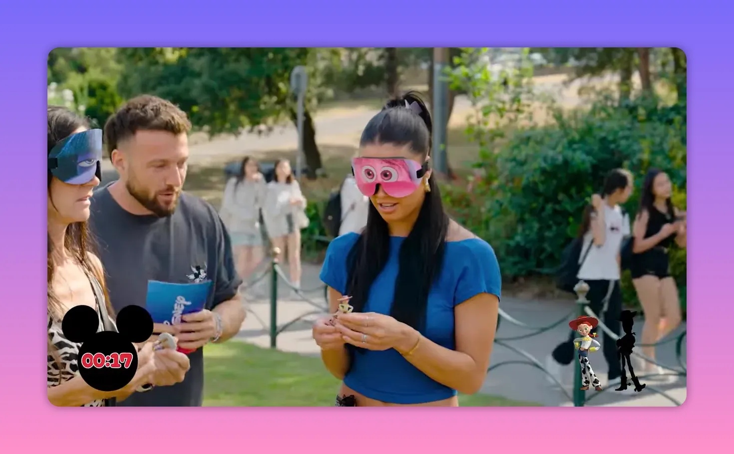 Blindfolded woman in a blue top holding a small Woody/Jessie style figurine while preparing to guess the character in the tactile challenge.