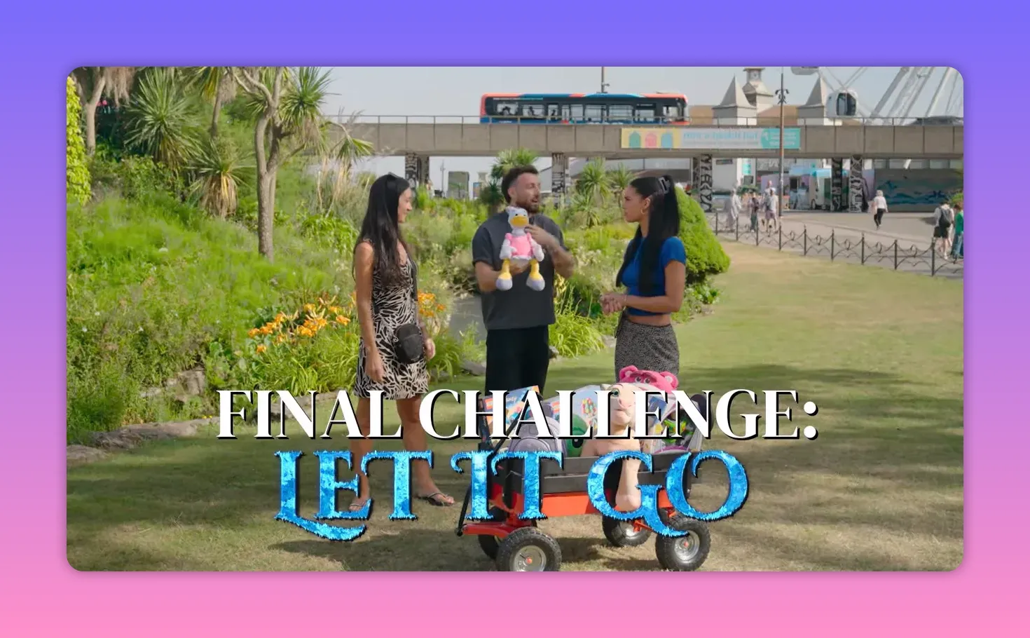 On-screen title 'FINAL CHALLENGE: LET IT GO' over a shot of the host and two contestants with a wagon of prizes in a sunny park.