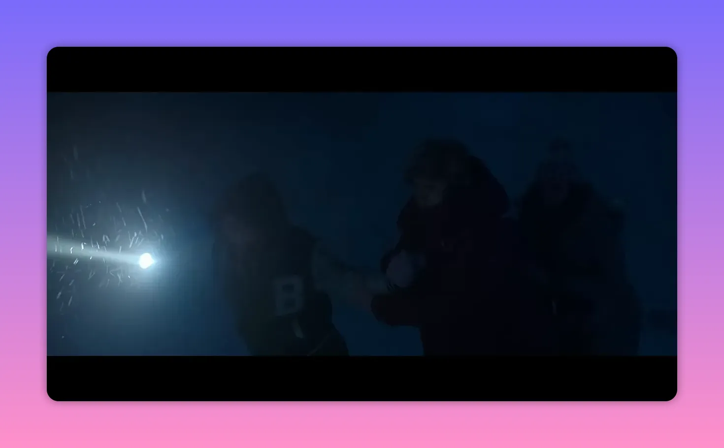 three people linked together moving through a snowy storm with a flashlight beam