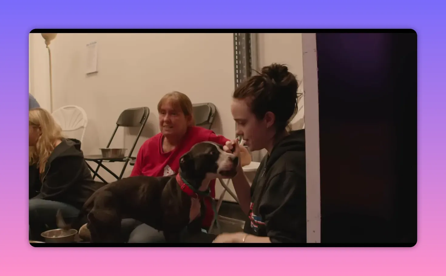 Performer crouched backstage interacting with a dog while crew members sit nearby